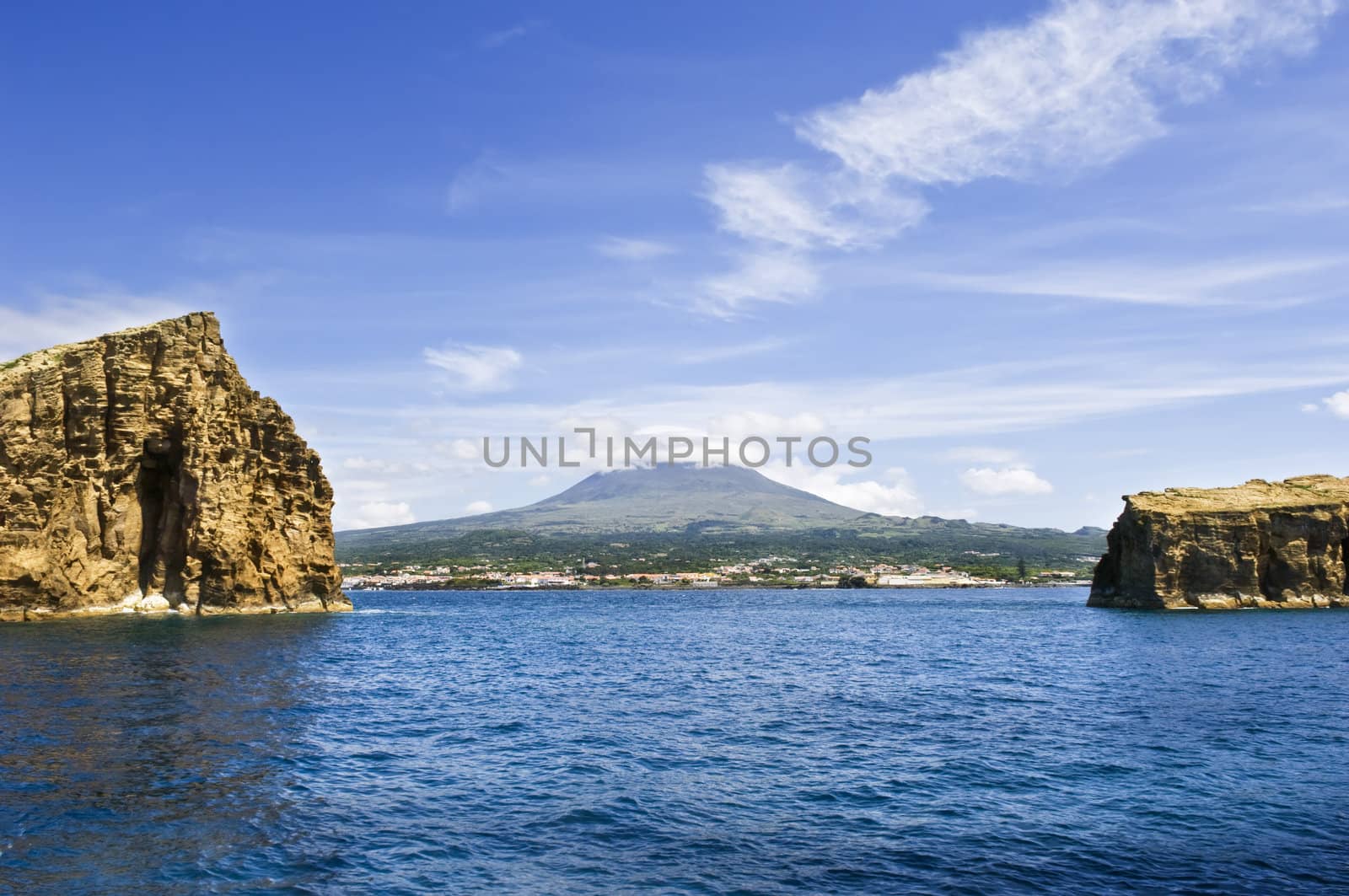 View from the sea of Pico Island, the volcano and the village of Madalena between two islets
