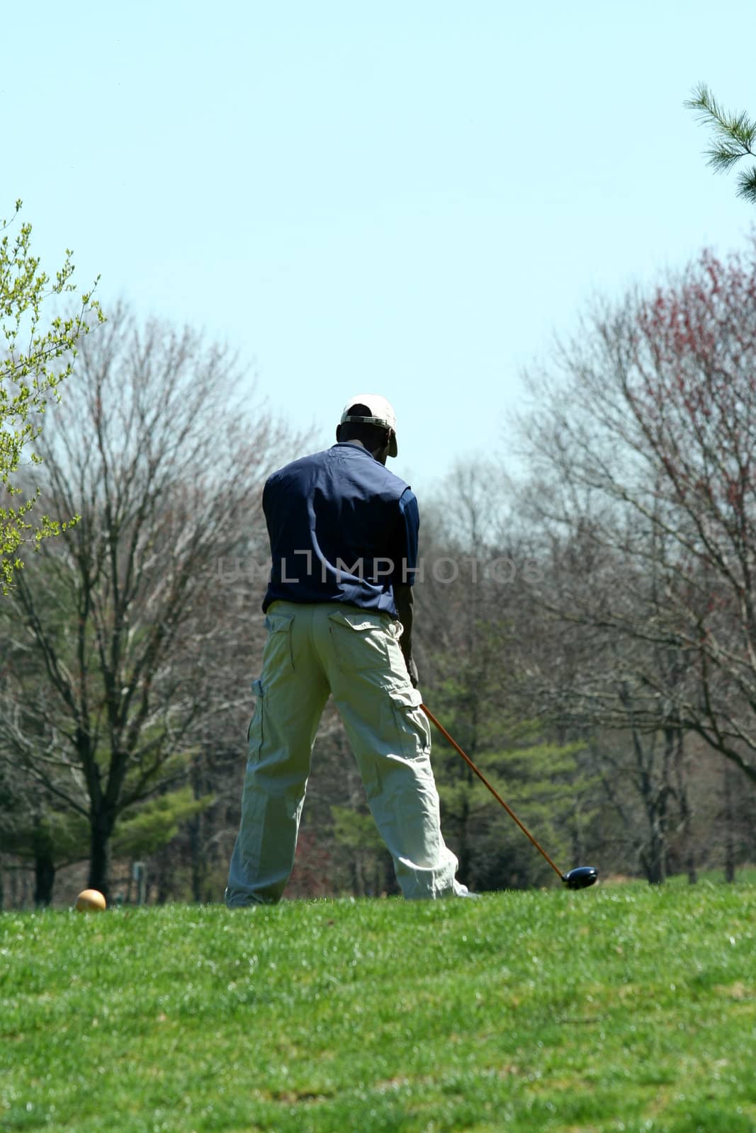 A Male golfer teeing off on a ball