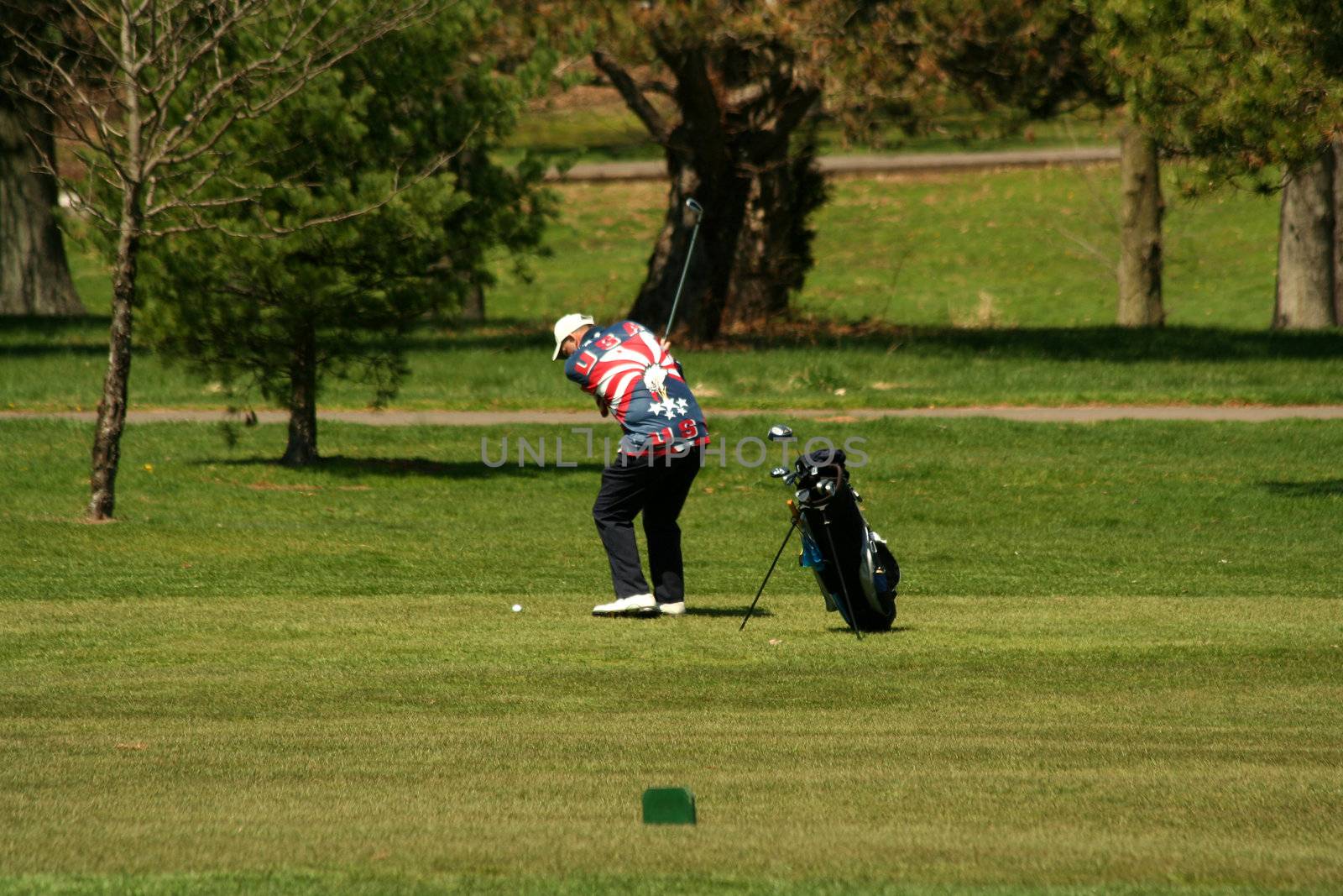 A Male golfer chipping to the green