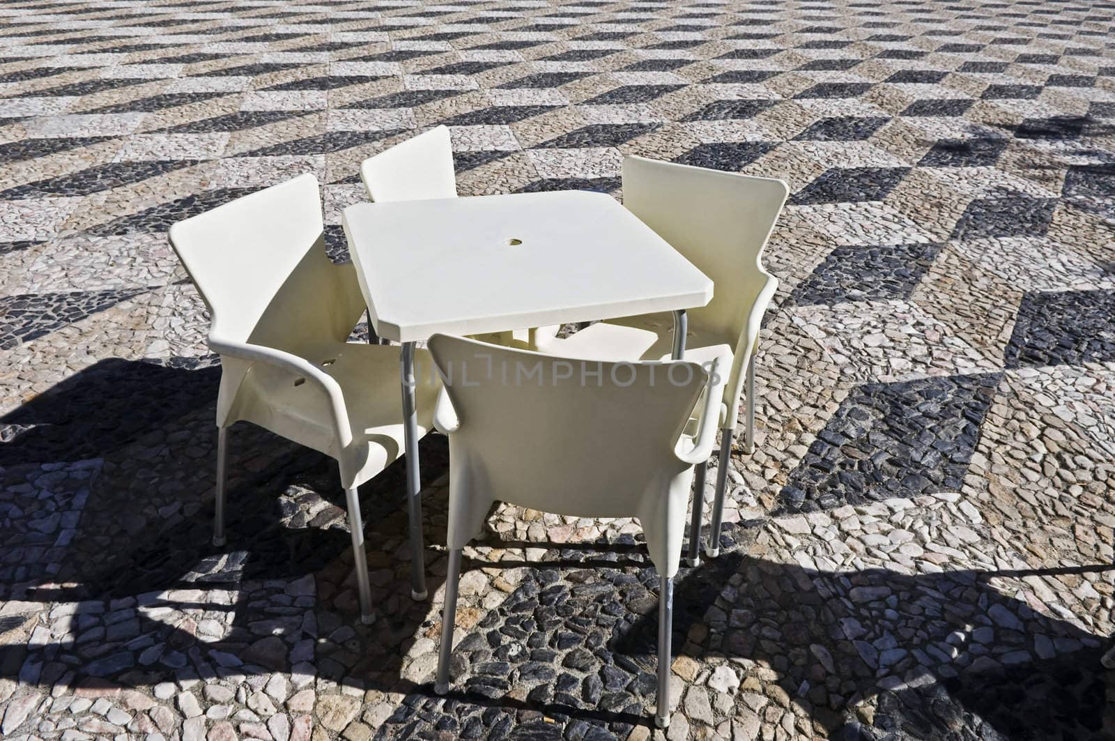 Modern coffee table in a traditional Portuguese stone paved plaza
