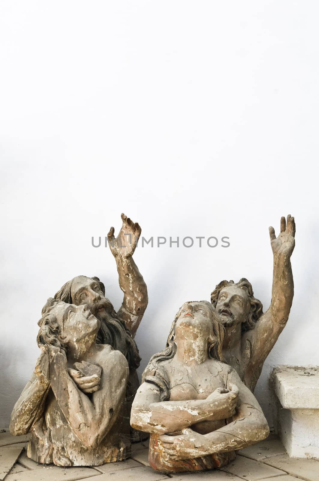 Abandoned wood sculptures of saints pointing above
