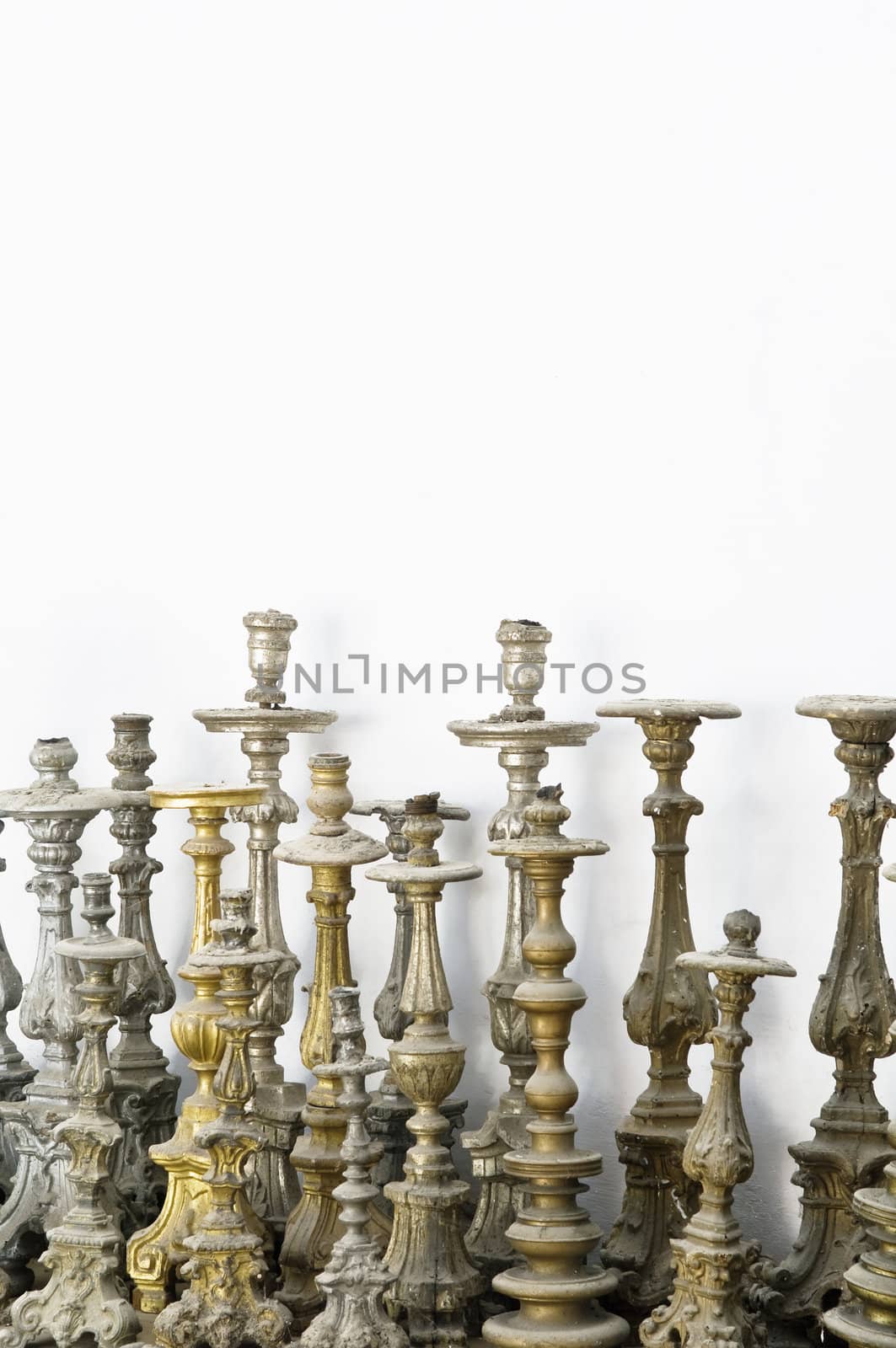 Large group of abandoned candlesticks covered with dust
