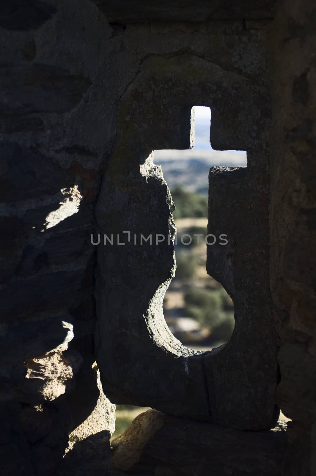 Cross shaped loophole in the walls of the castle of Monsaraz, Alentejo, Portugal