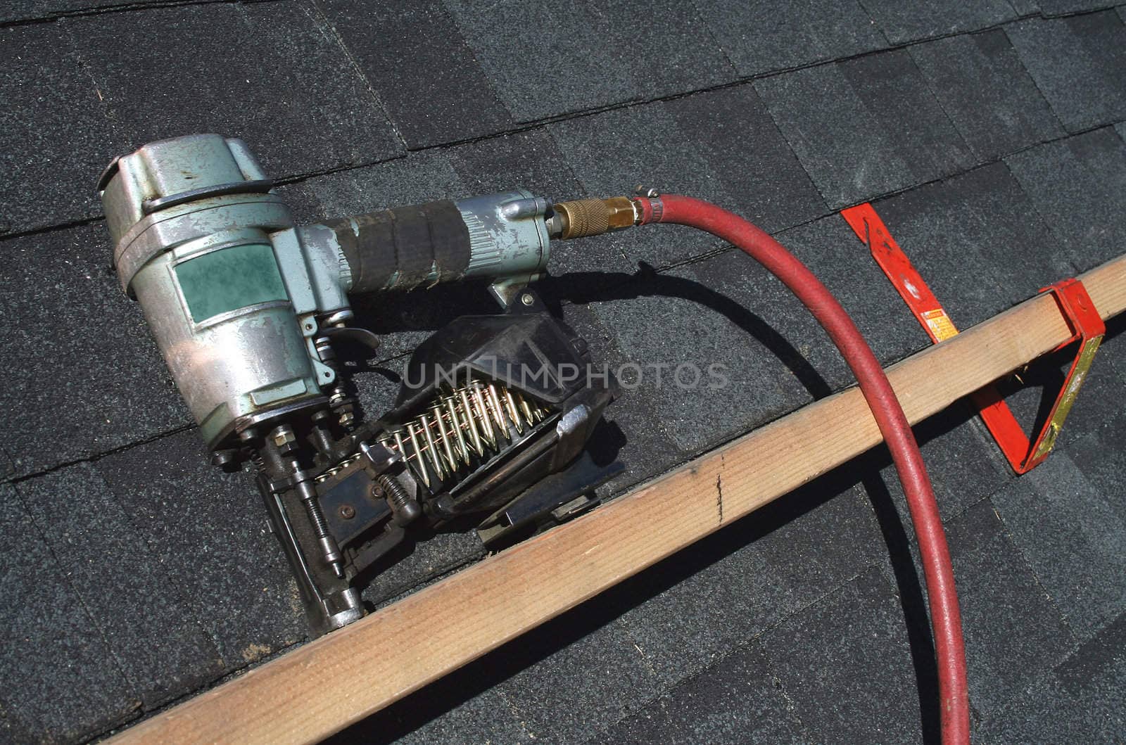 A Pneumatic roofing nail gun with air hose