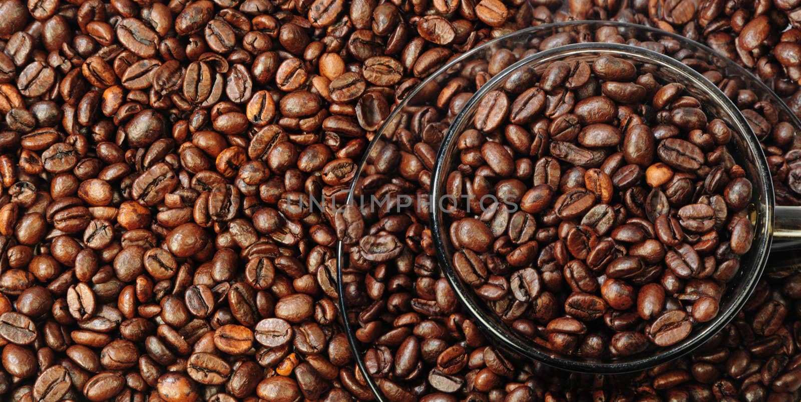 there are outlines of cup and saucer in-bulk coffee grains as background