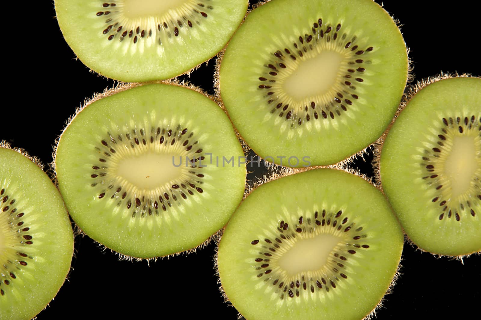 Thin slices of kiwi fruit on black background