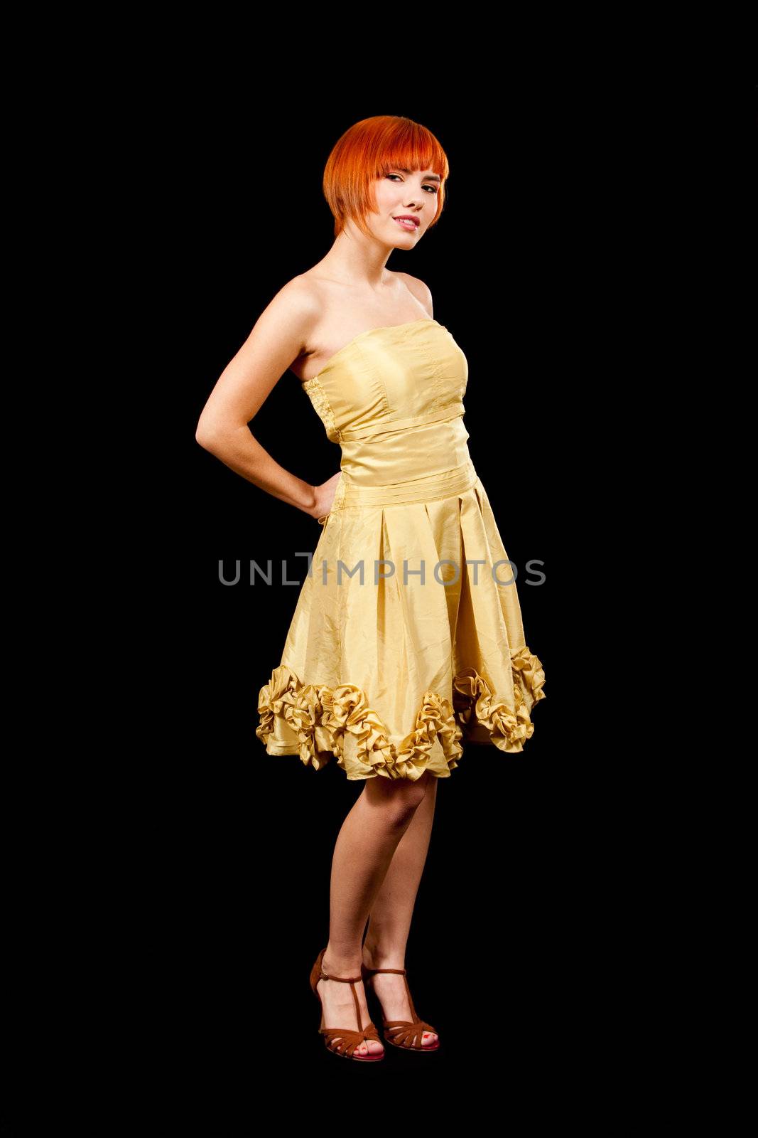 Beautiful Caucasian redhead woman in yellow cocktail dress, isolated