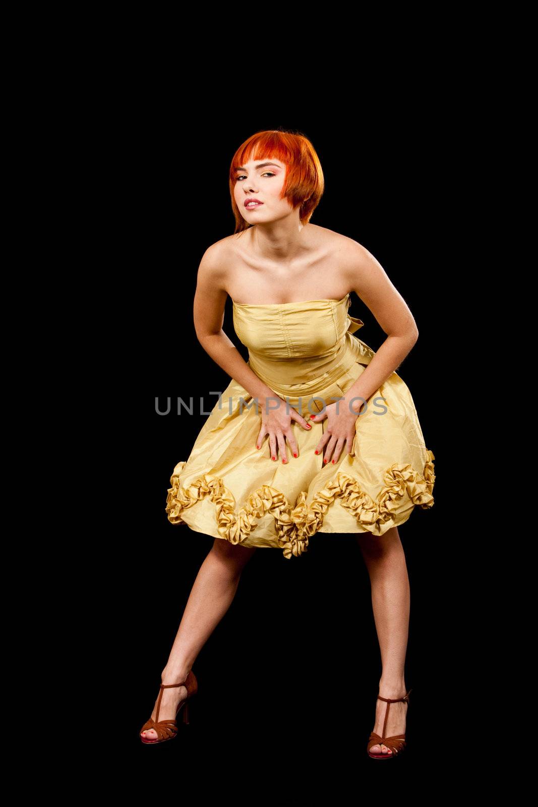Beautiful Caucasian redhead woman in yellow cocktail dress, isolated