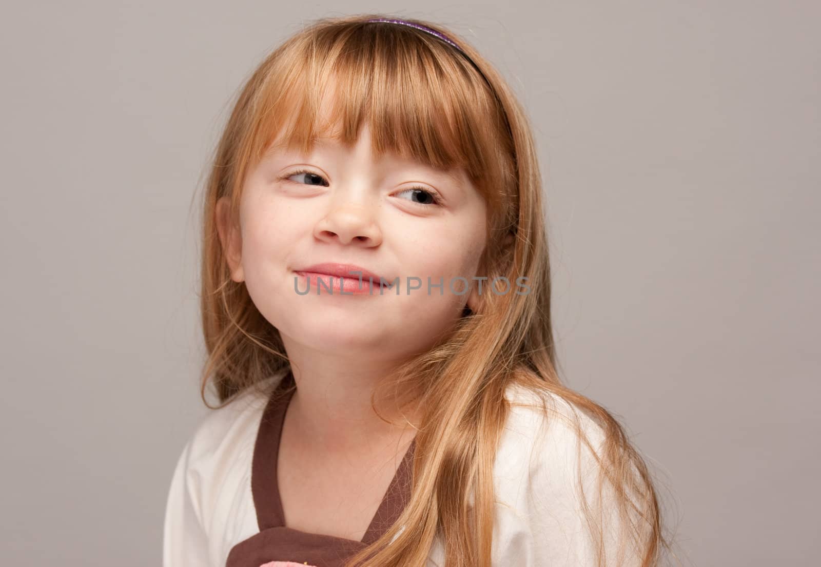 Portrait of an Adorable Red Haired Girl on a Grey Background.