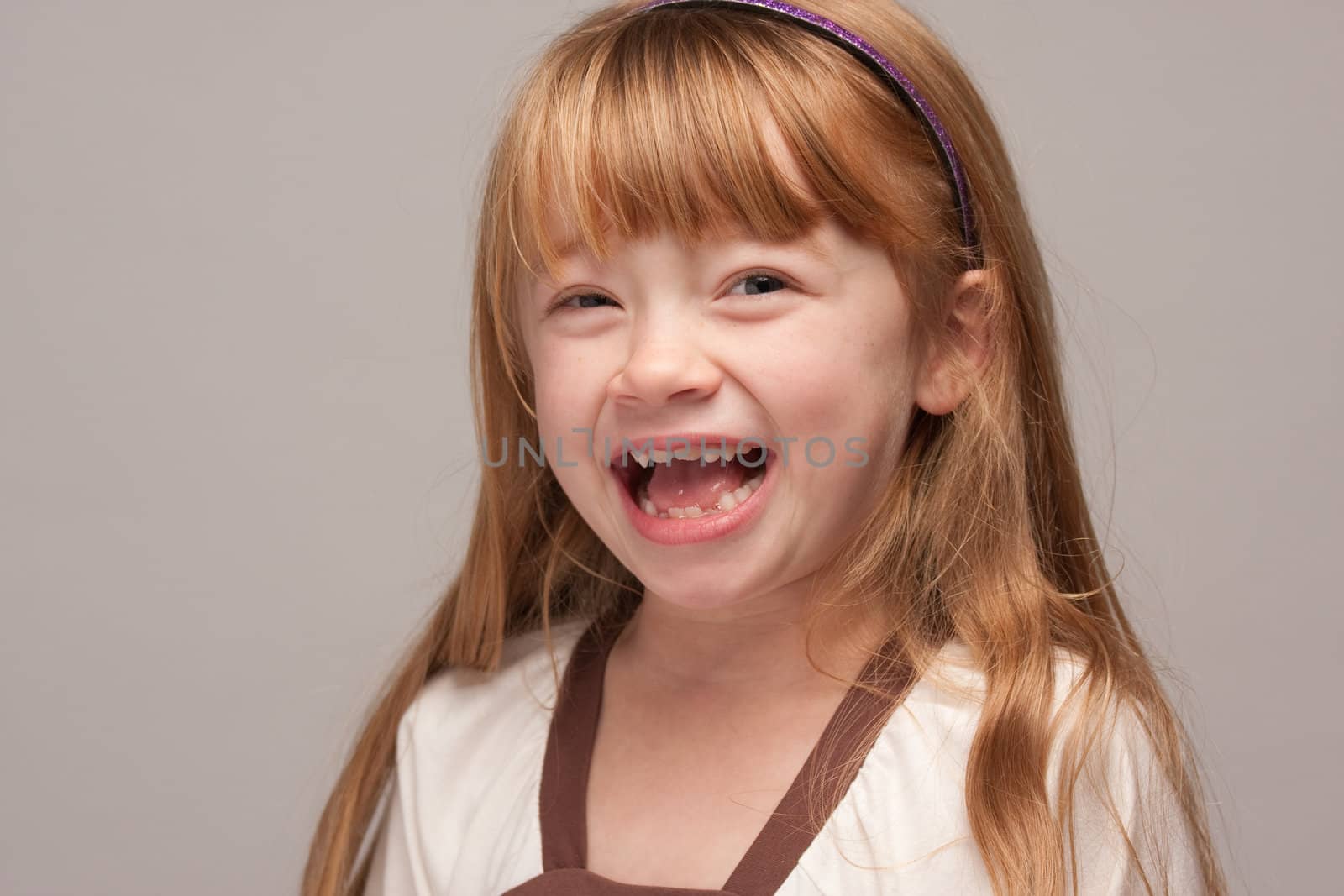 Portrait of an Adorable Red Haired Girl on a Grey Background.