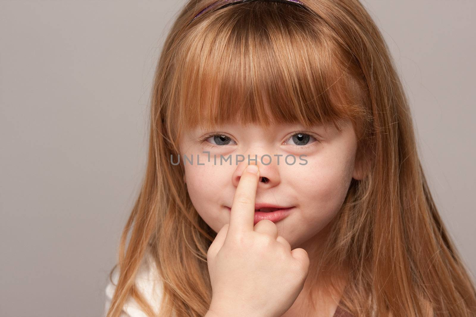 Portrait of an Adorable Red Haired Girl on a Grey Background.