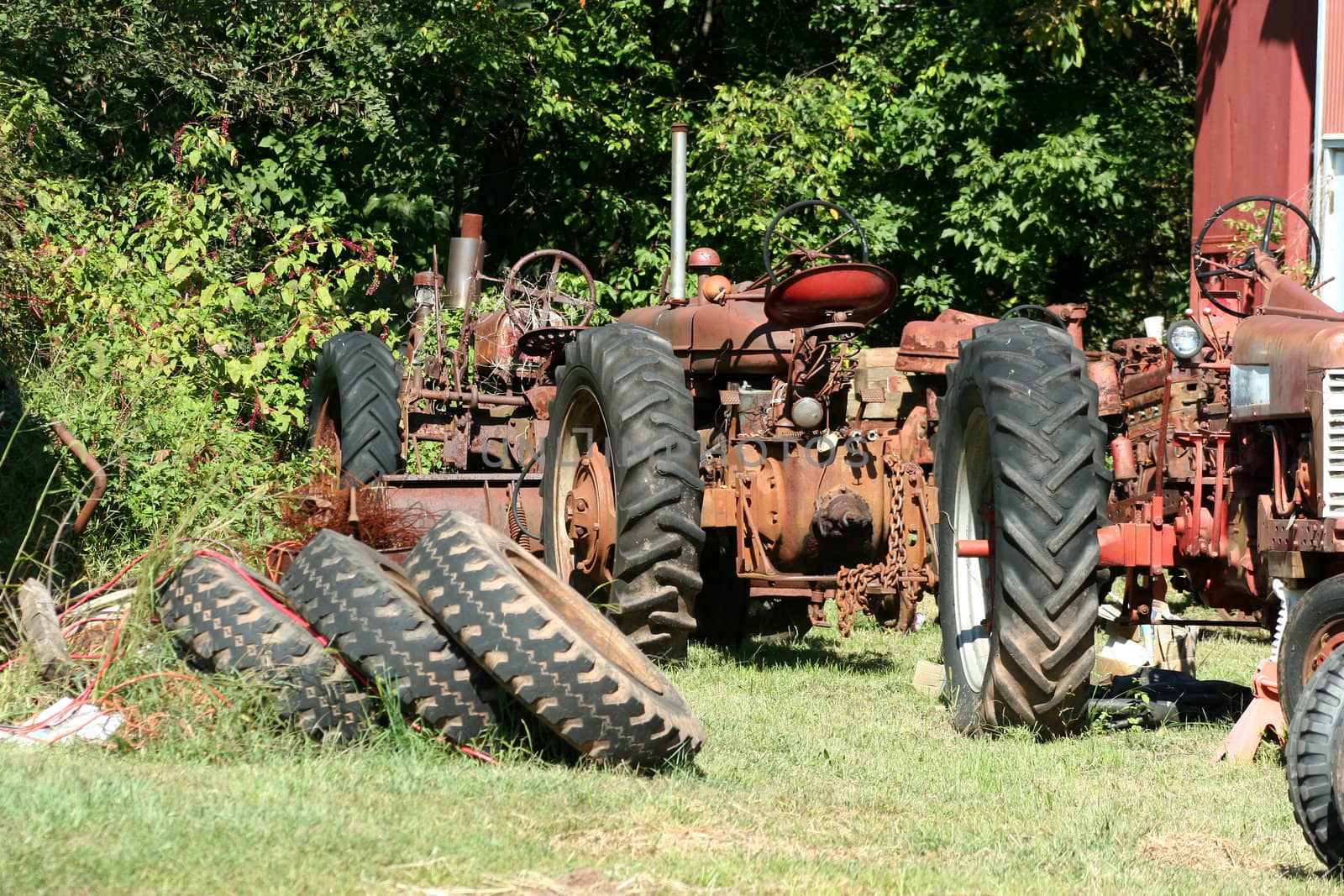 Two Old red tractors with tires