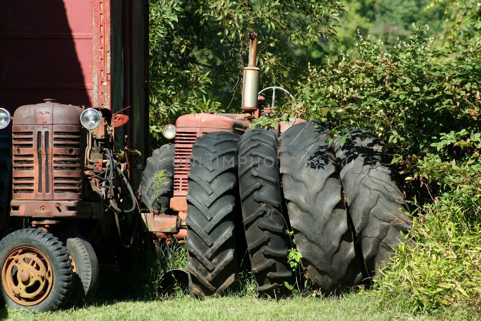 Two Old red tractors with tires