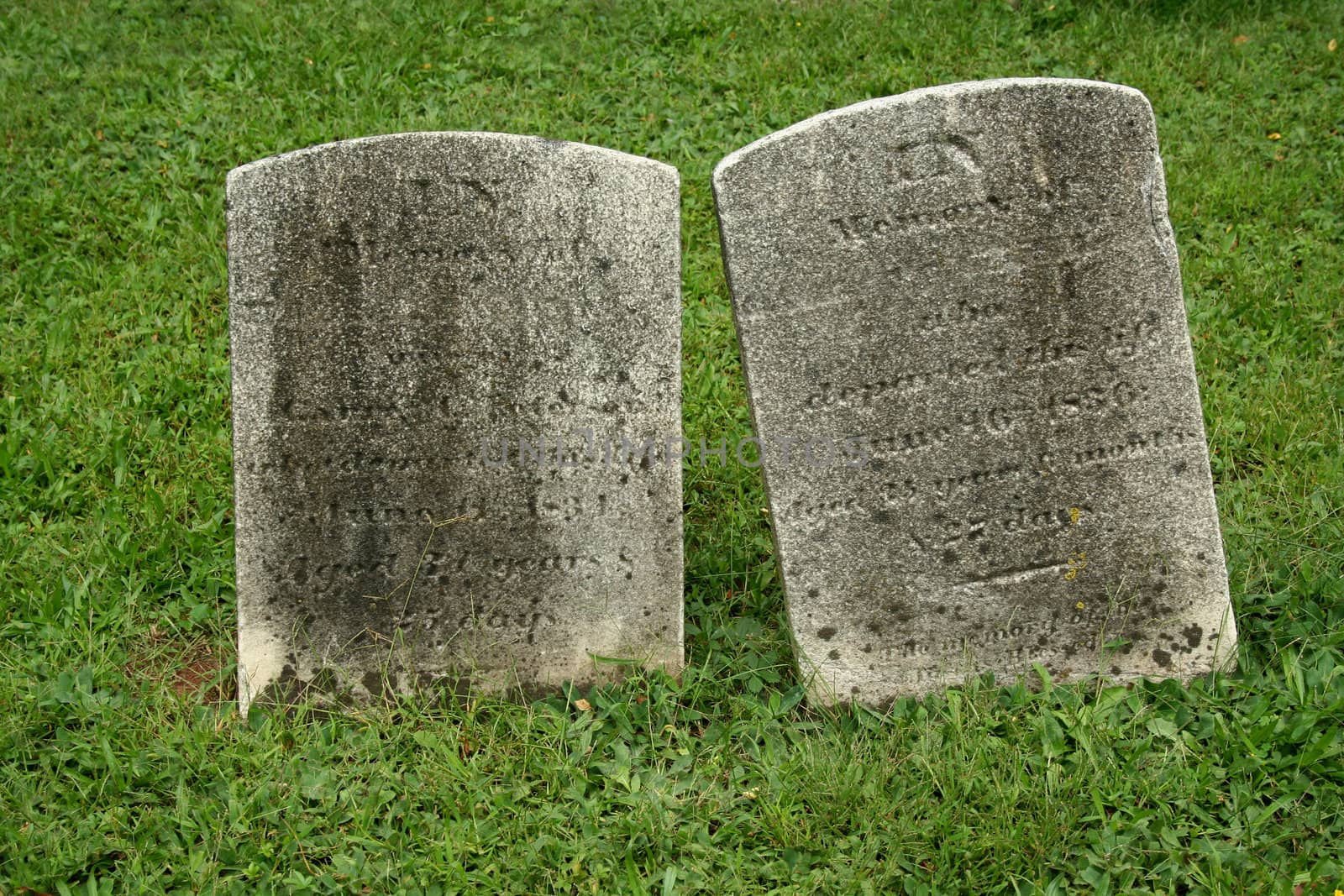 Two Old Gravestone with grass in a graveyard