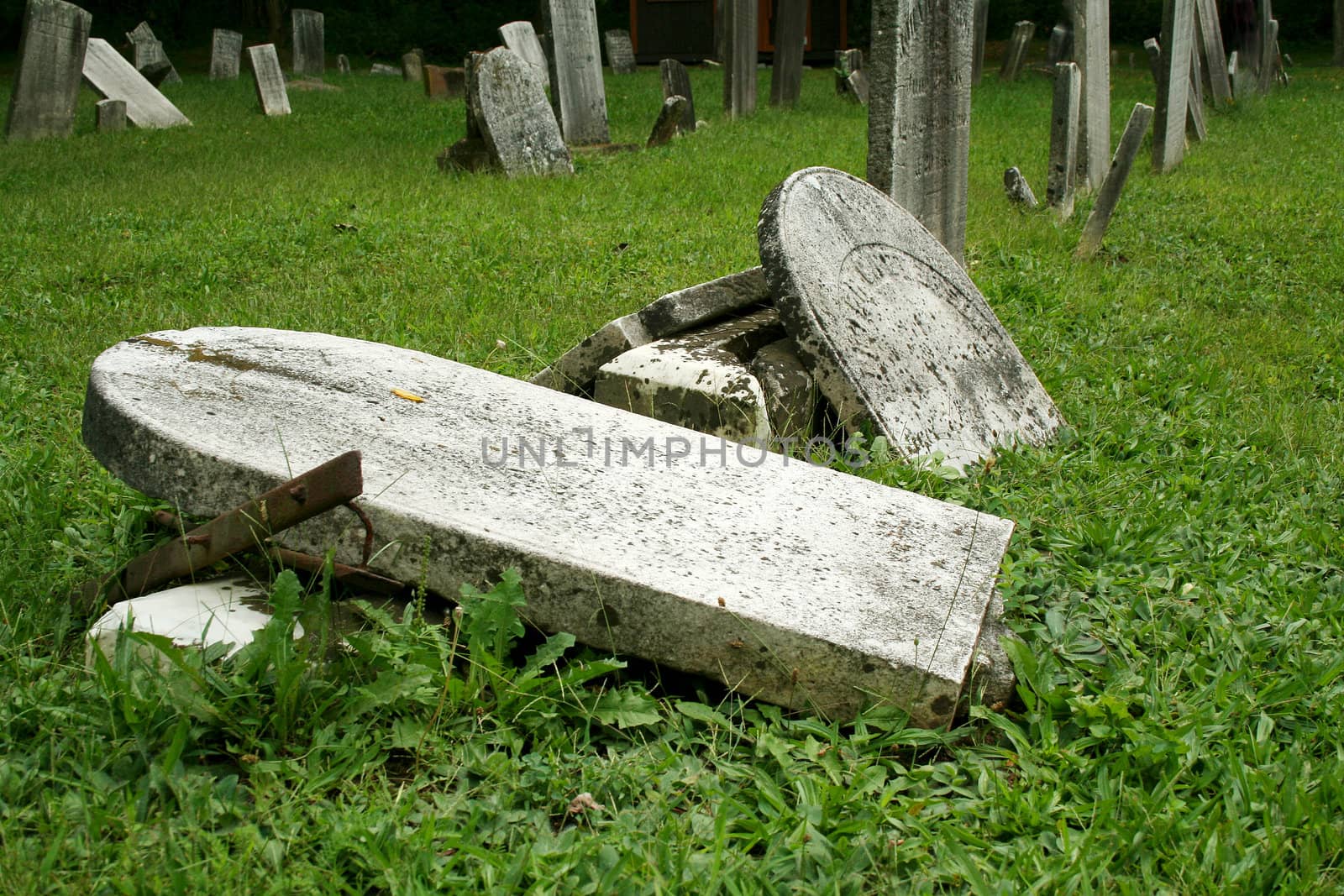 Broken Old Gravestones with grass in a graveyard