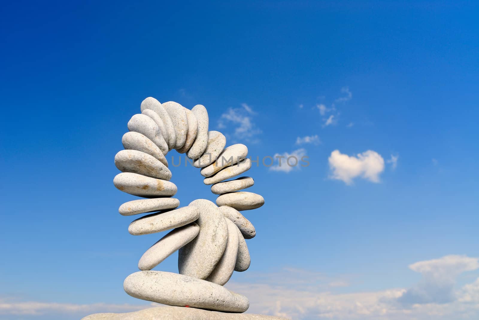 Connected ring of pebbles on a background of clouds