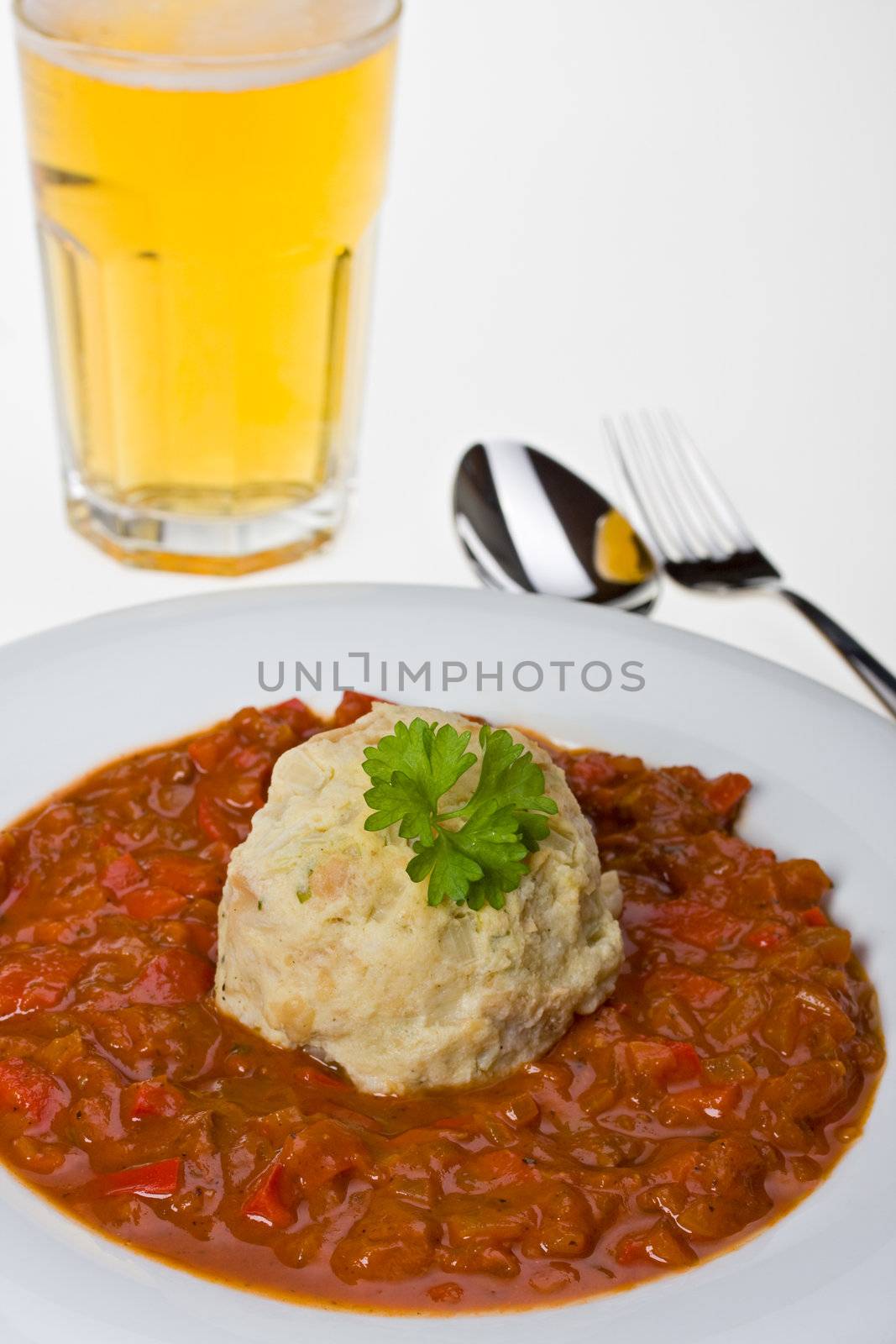 hungarian goulash and a bread dumpling on a white plate