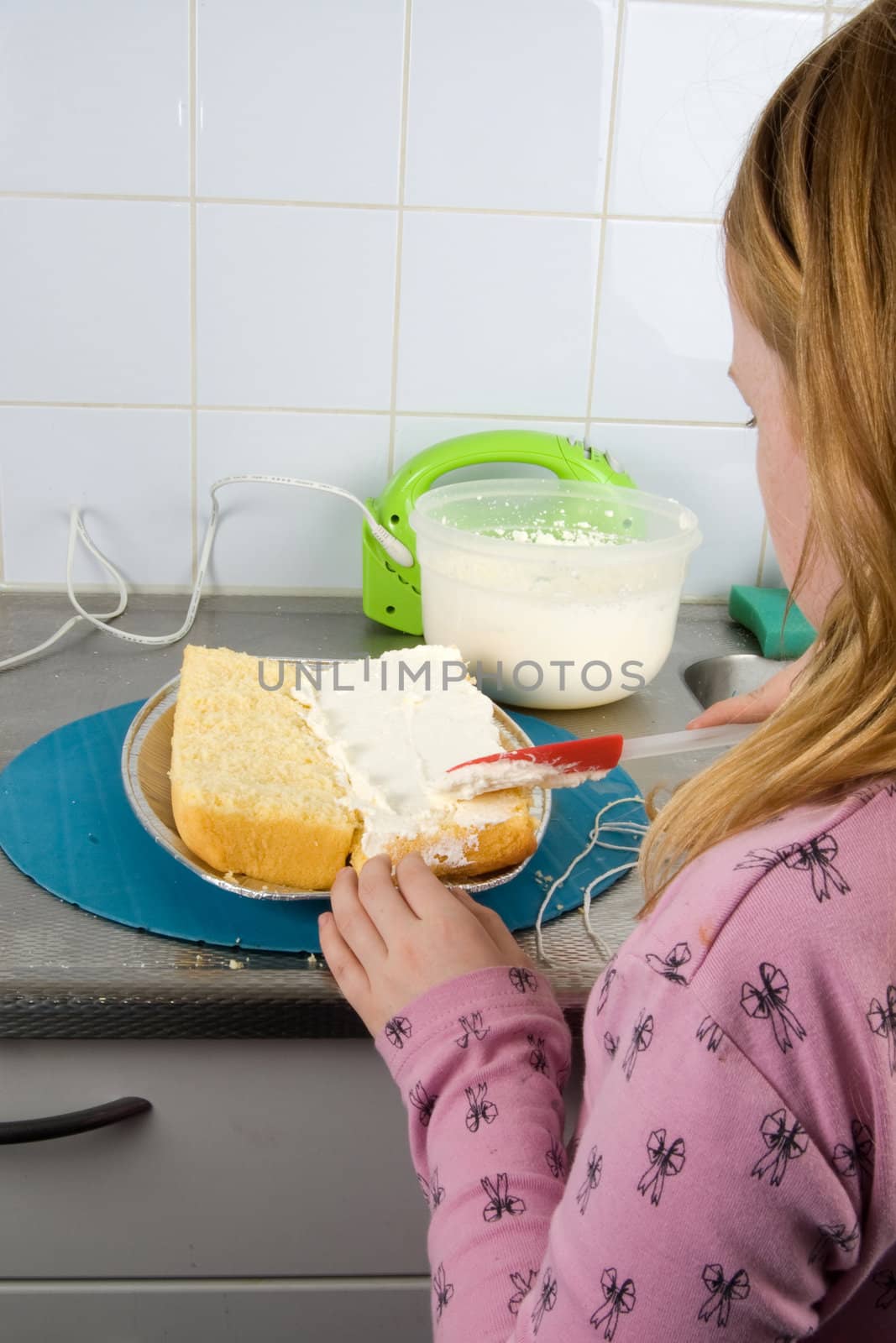girl is decorating a cake with whipped cream