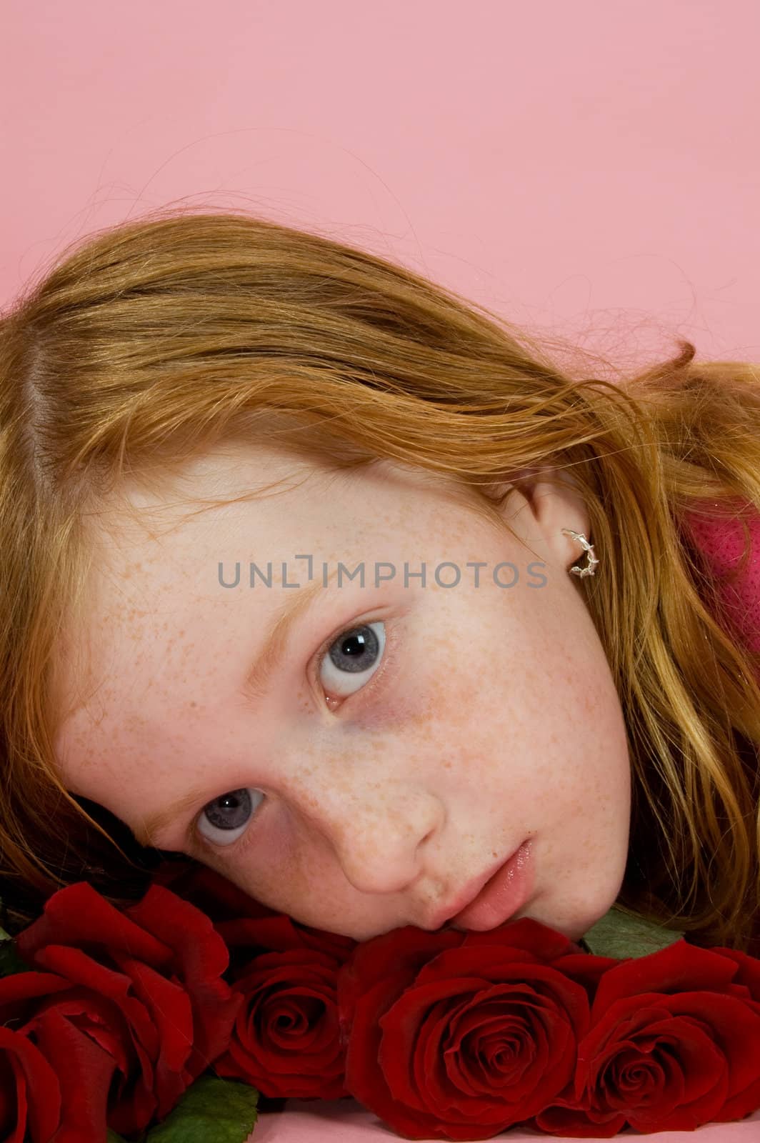 red head girl laying on some red roses by ladyminnie