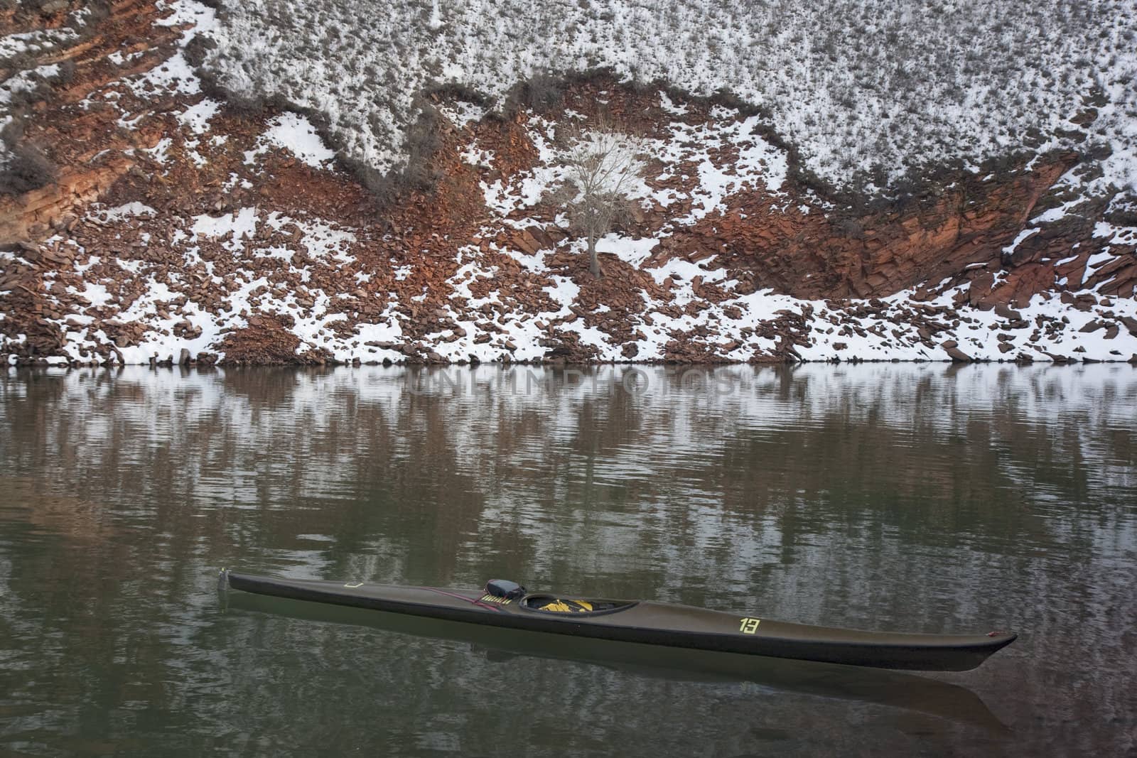 long, narrow, racing kayak on mountain lake by PixelsAway