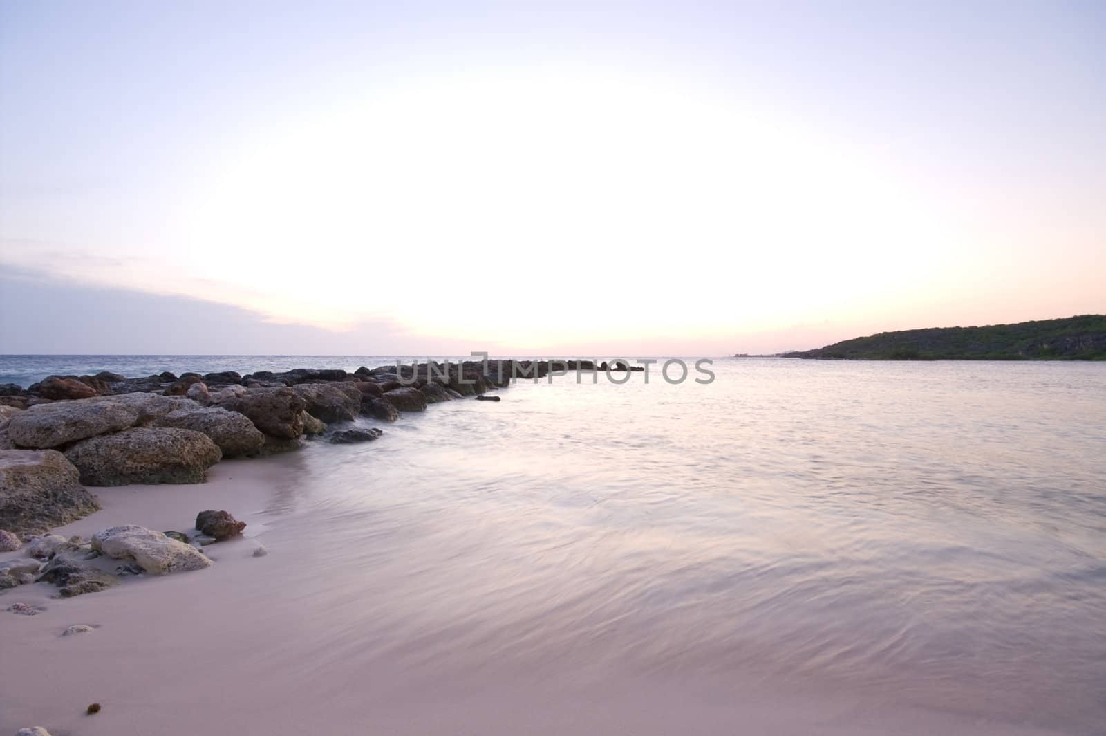 purple blue sea sunset with a rock wave breaker 
