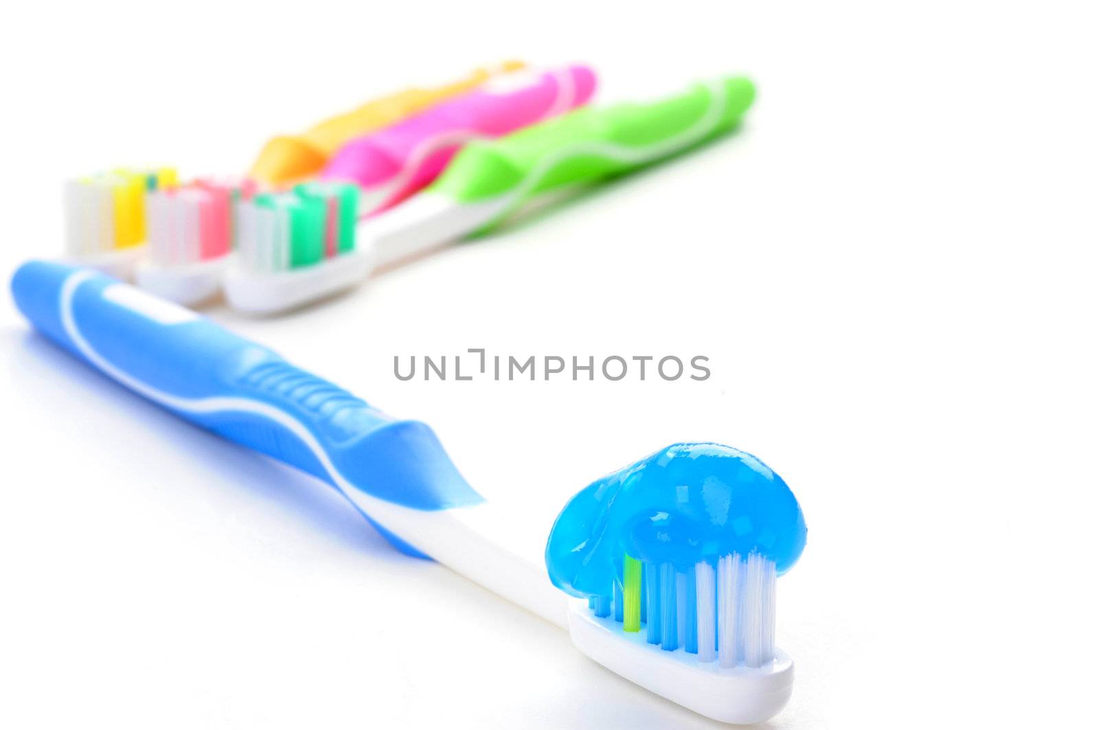 Blue toothbrush loaded with toothpaste on a white background.