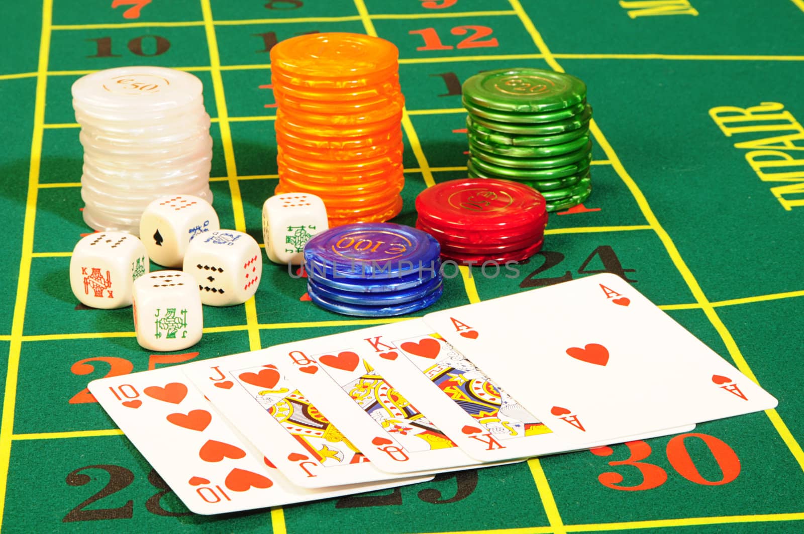 Casino chips,playing bones and royal flash combination on green felt