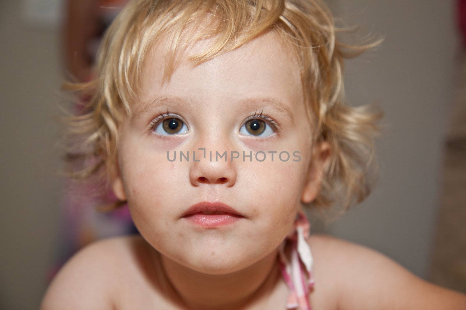 Portrait of cute little European toddler girl having fun and smiling.