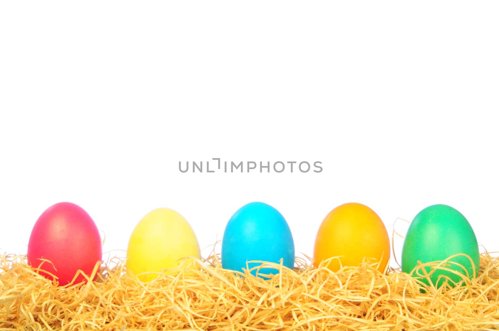 five painted eggs on a straw on a white background