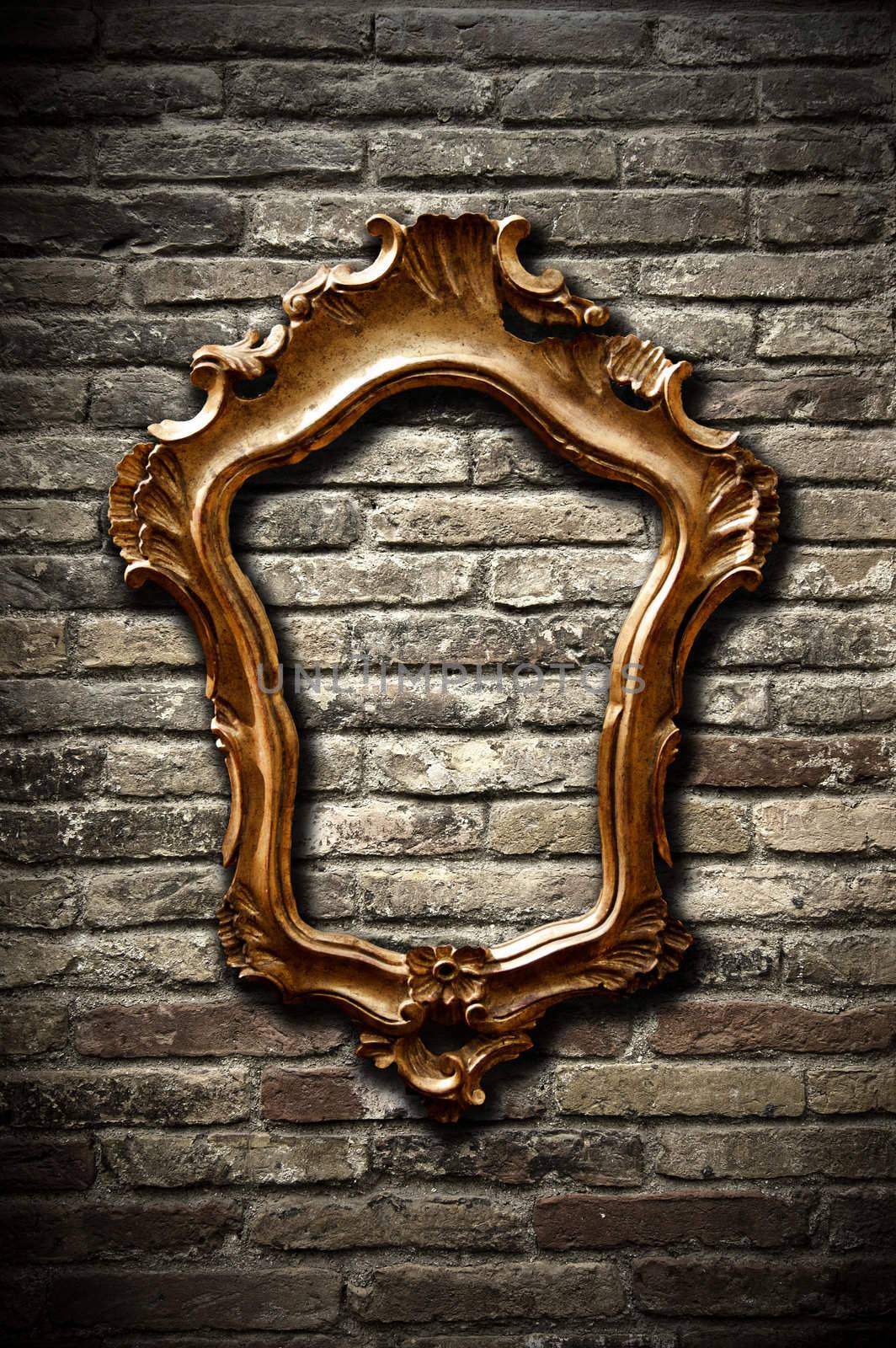 A vintage golden frame on a dark brick wall