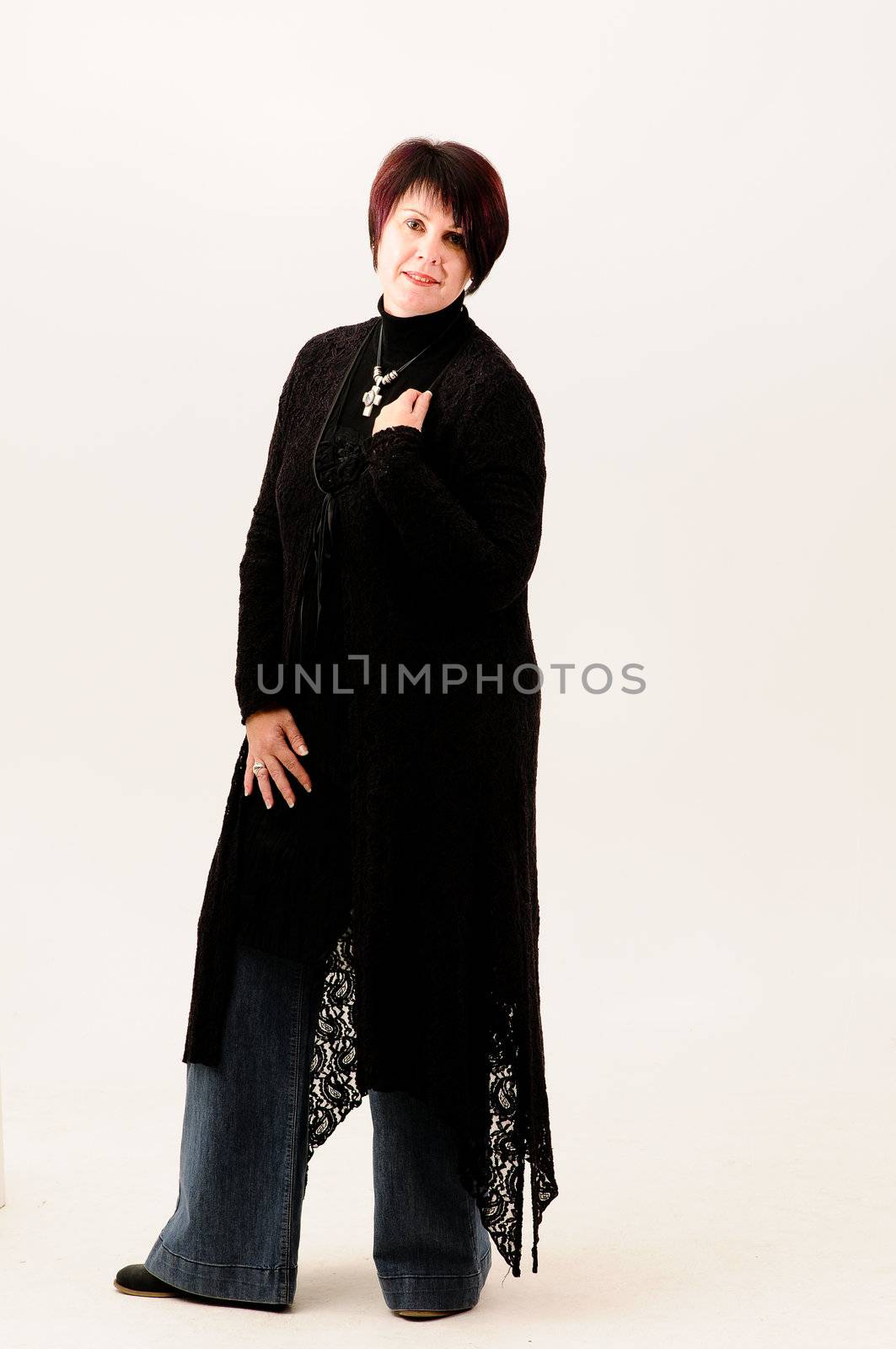 Beautiful attractive fuller figure mature short haired woman dressed in jeans and black knitted jacket