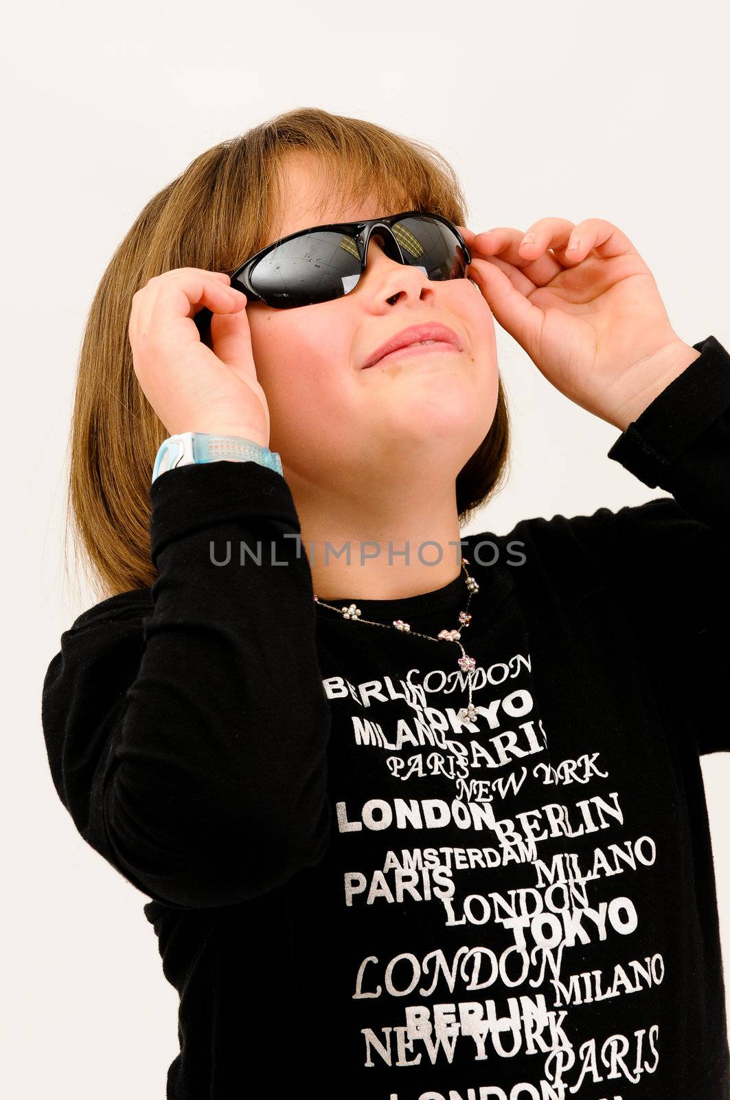 young beautiful  teenager touching  sun glasses smiling with dimple in cheek looking up by Ansunette