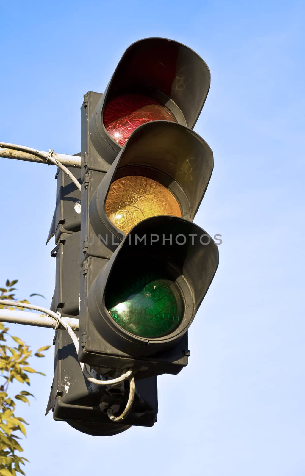 Old traffic light against the blue sky.