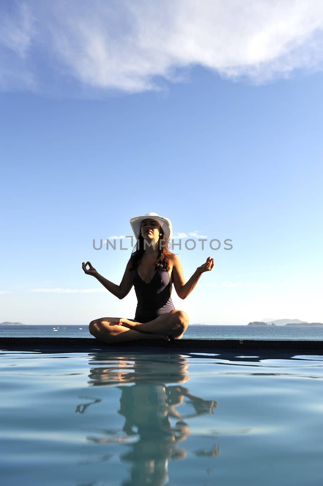 Woman relaxing on a swimming pool with a sea view
