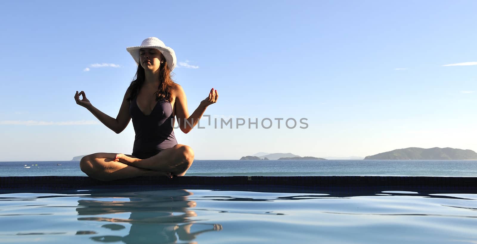 Woman relaxing on a swimming pool with a sea view
