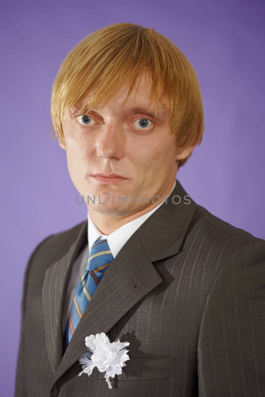 The groom looks at us - a portrait on the purple background