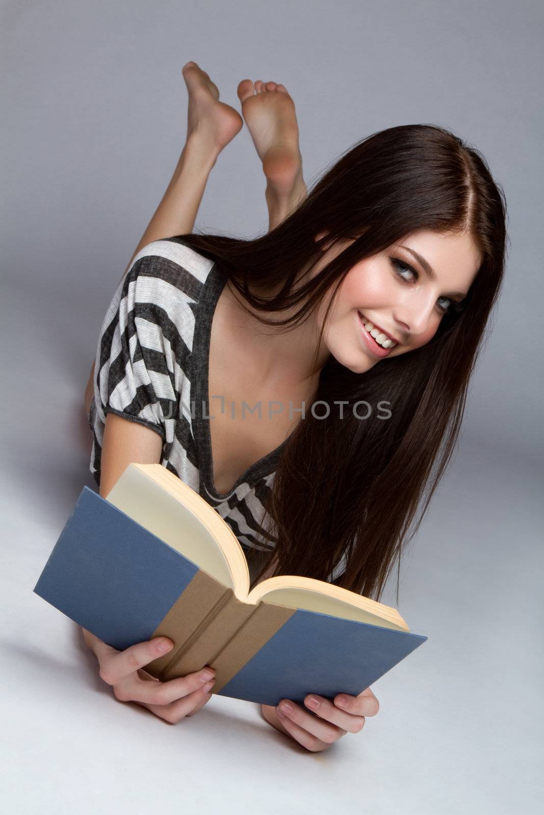 Pretty teenage girl reading book