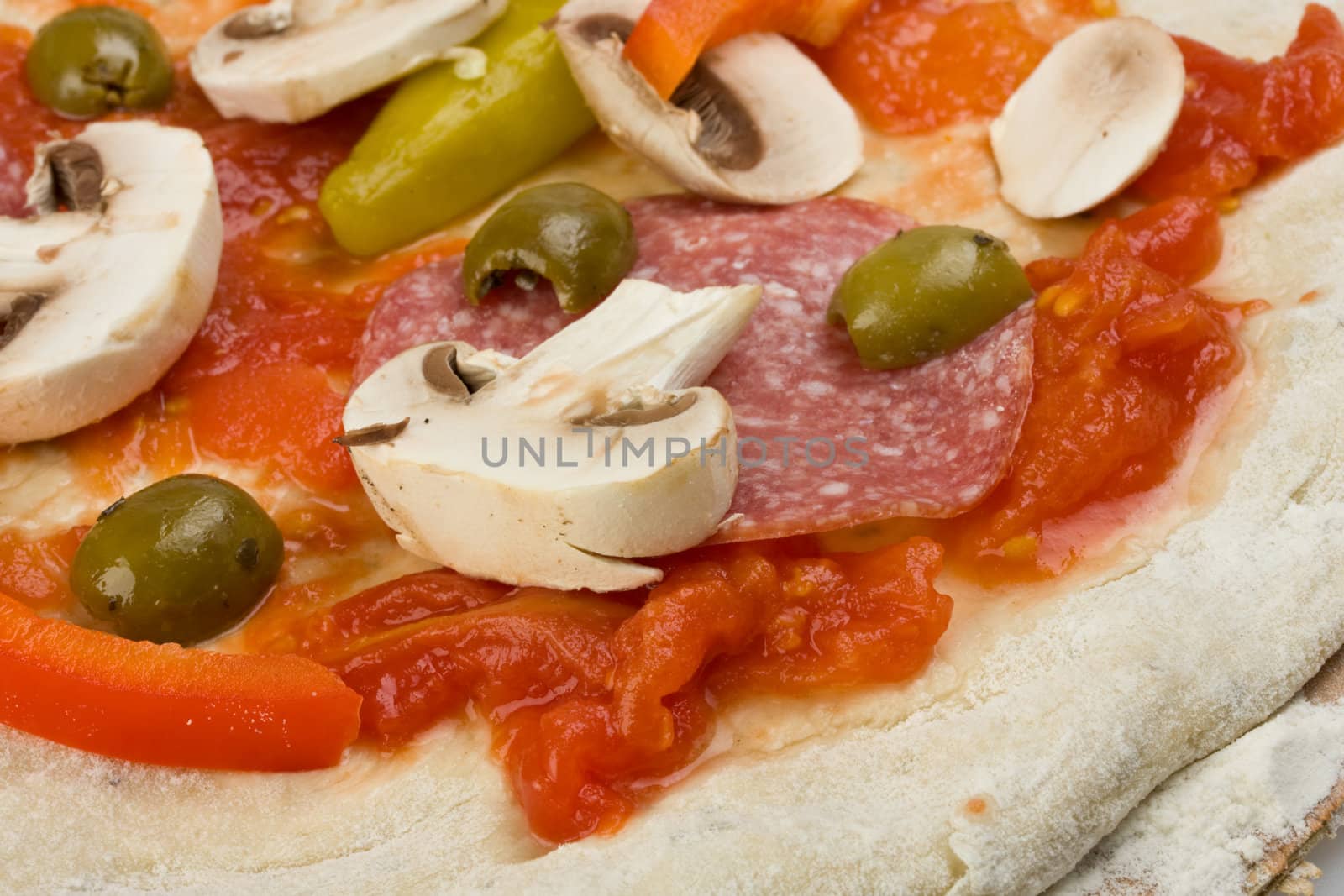 unbaked pizza prepared to bake on a wooden board by bernjuer