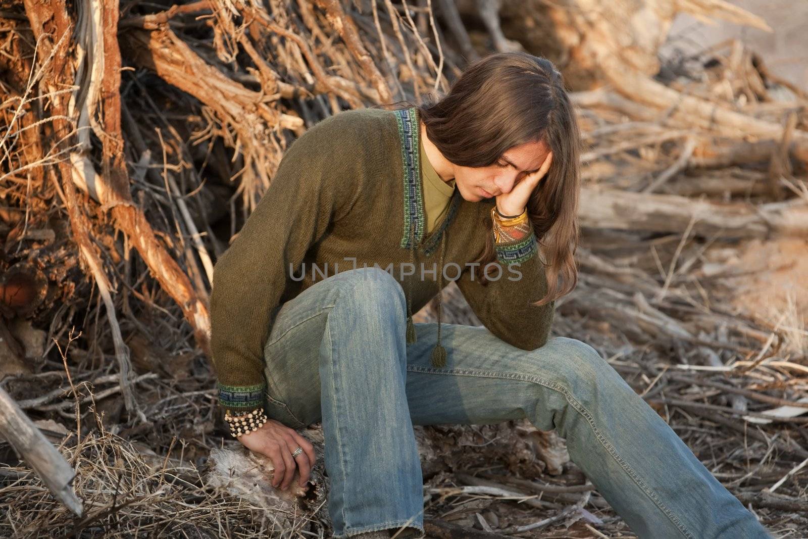 Handsome young man with long hair in an outdoor setting