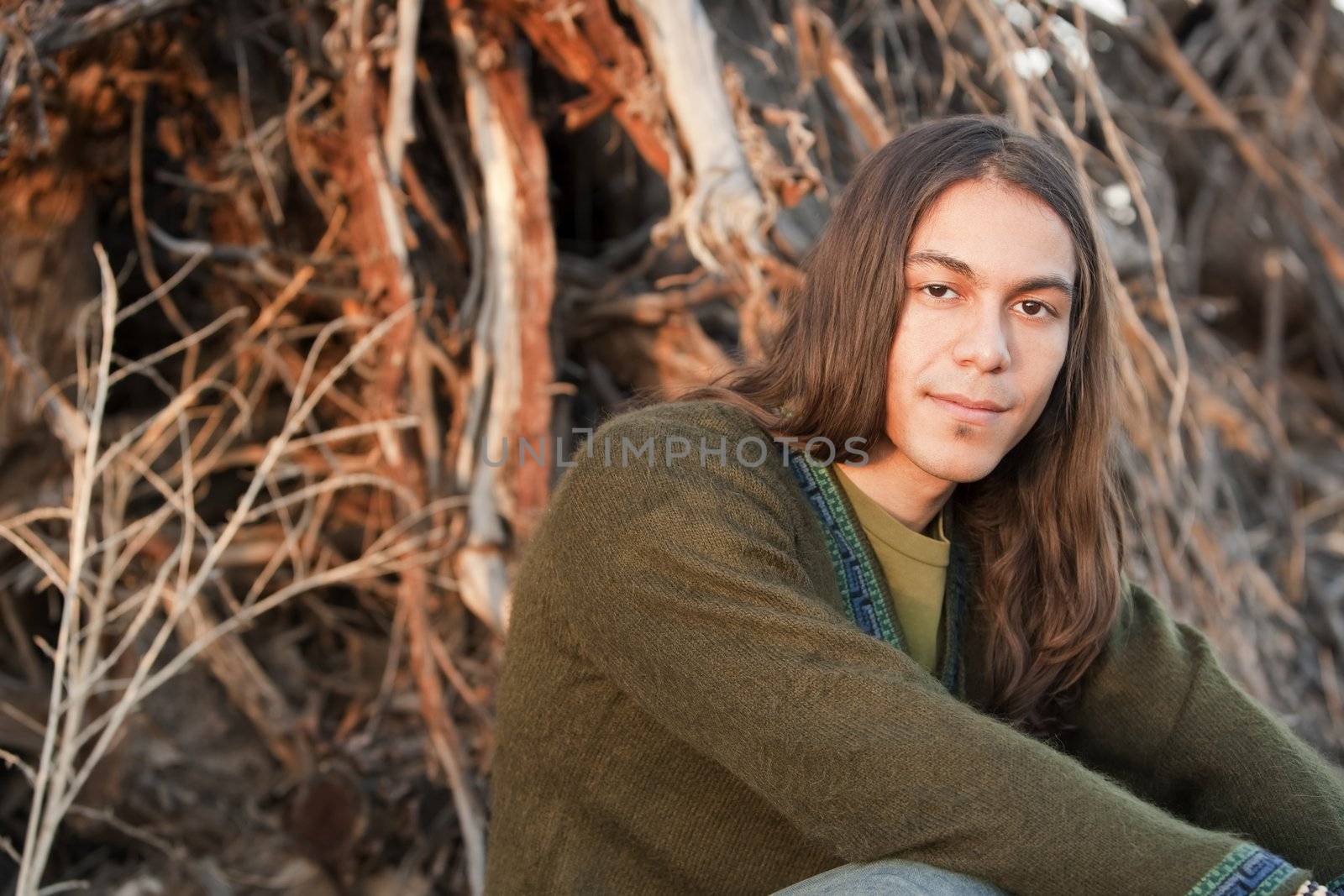 Handsome young man with long hair in an outdoor setting