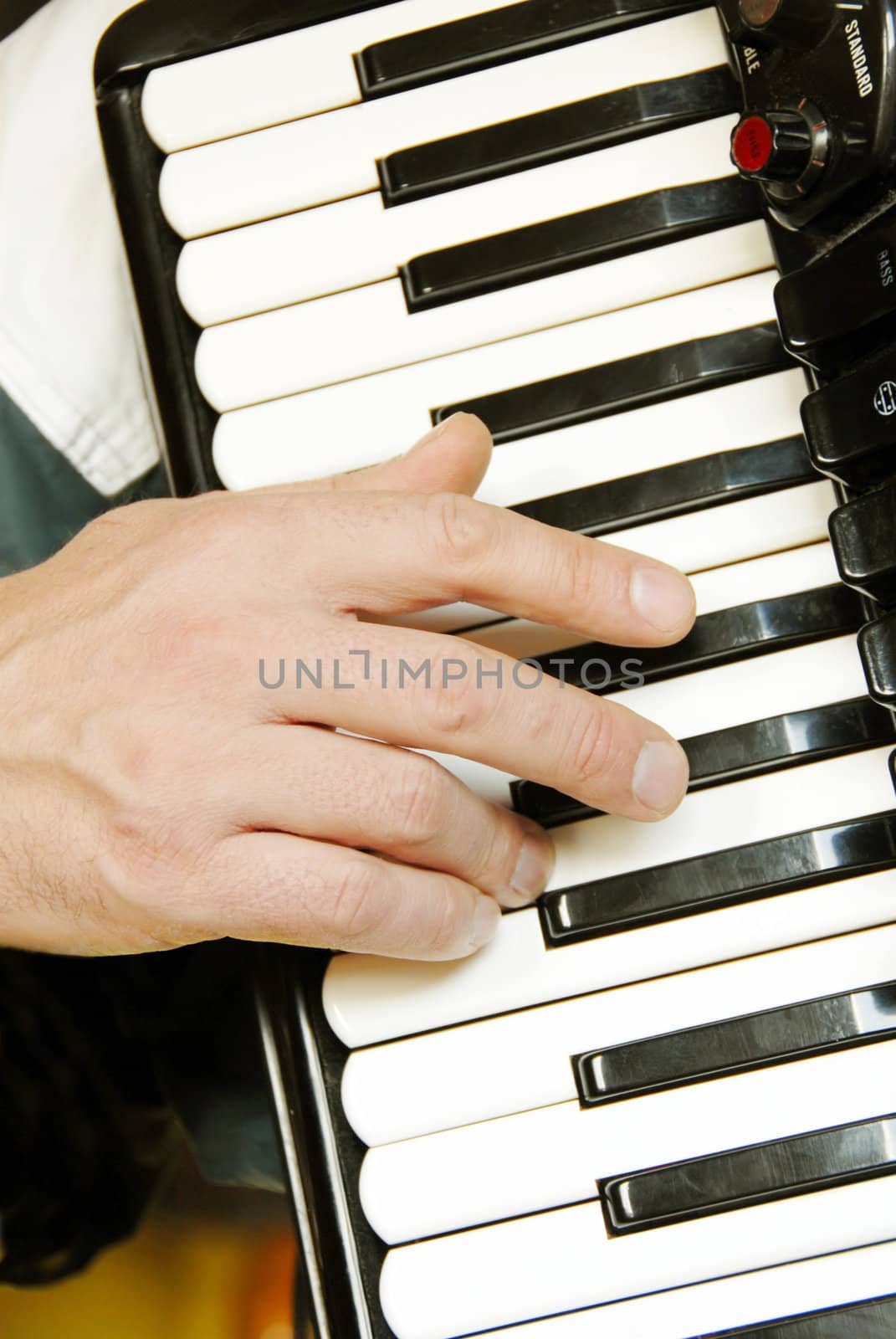 musician hand playing accordion closeup in dramatic shadows