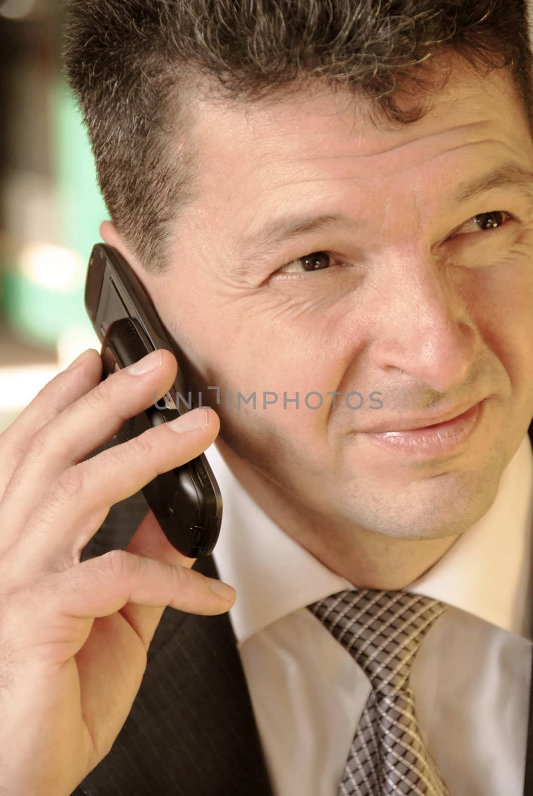business man with mobile phone in hand with unpleasant facial expression
