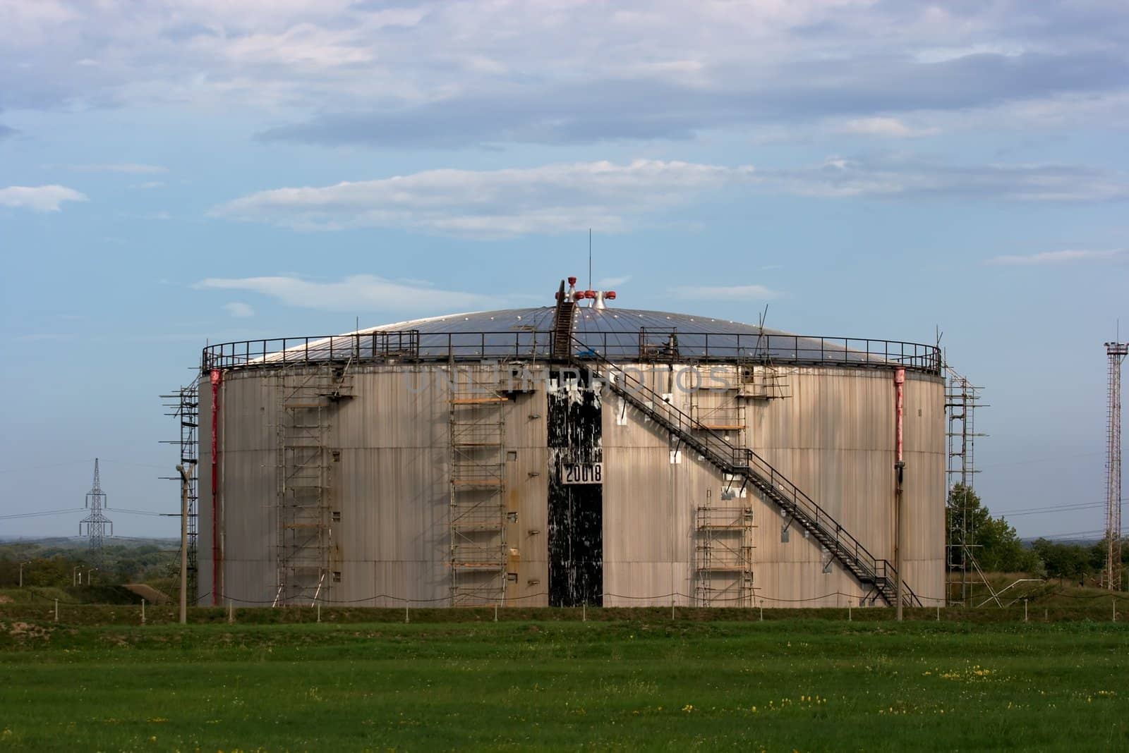 Big round oil silo on a field