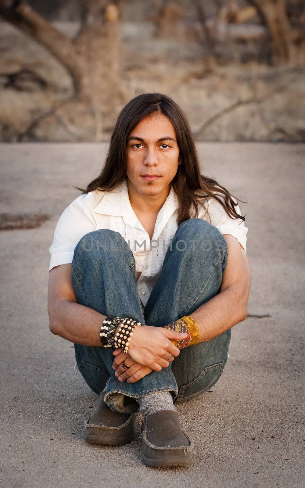 Handsome young man with long hair in an outdoor setting