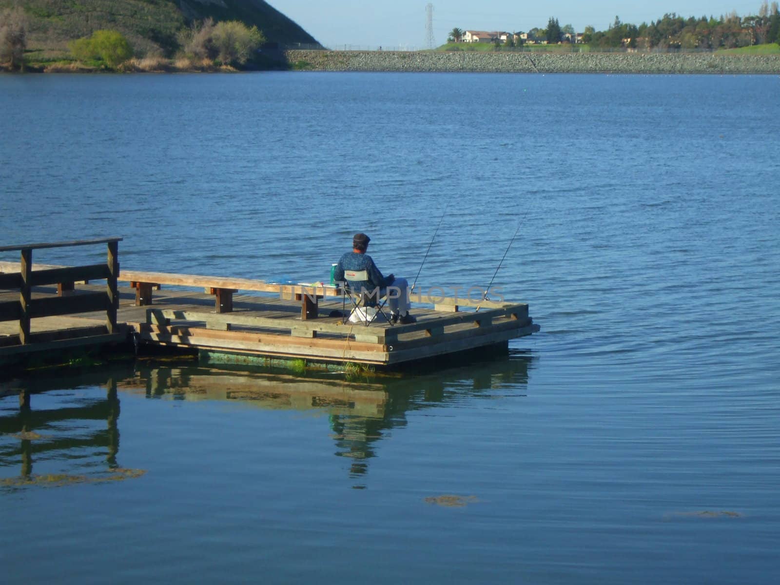 Fisherman fishing on a shore on a sunny day.