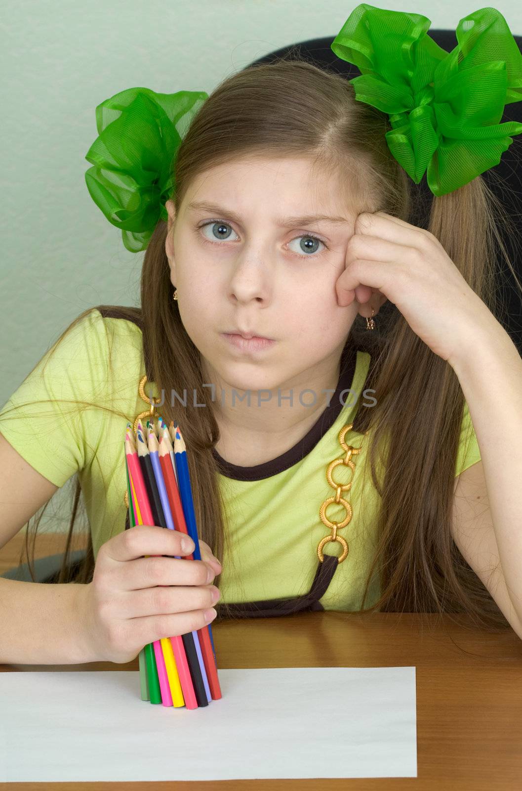 Girl with color pencils in hands and a sheet of paper