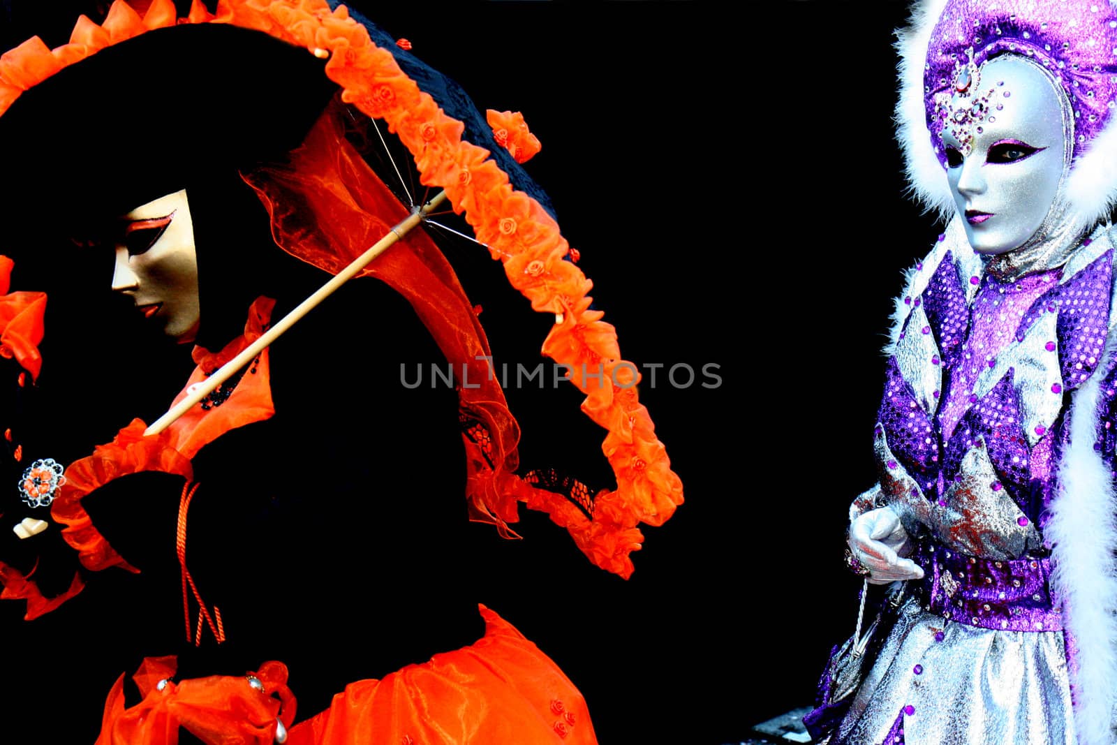 Two masked women, one with a parasol at the Venice Carnival