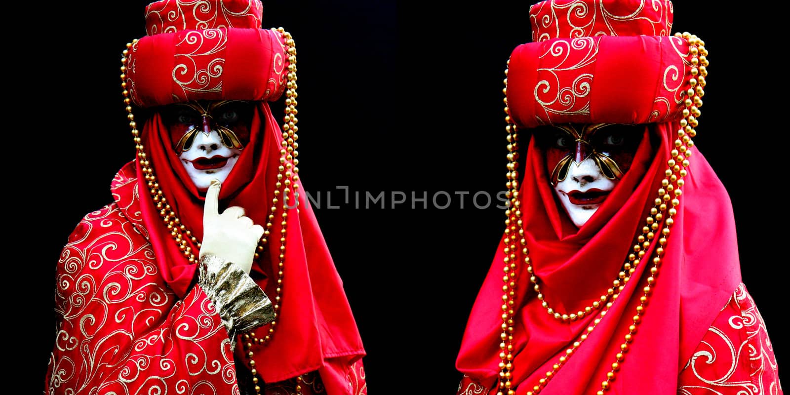 Two masked women, dressed in red on black background  at the Venice Carnival