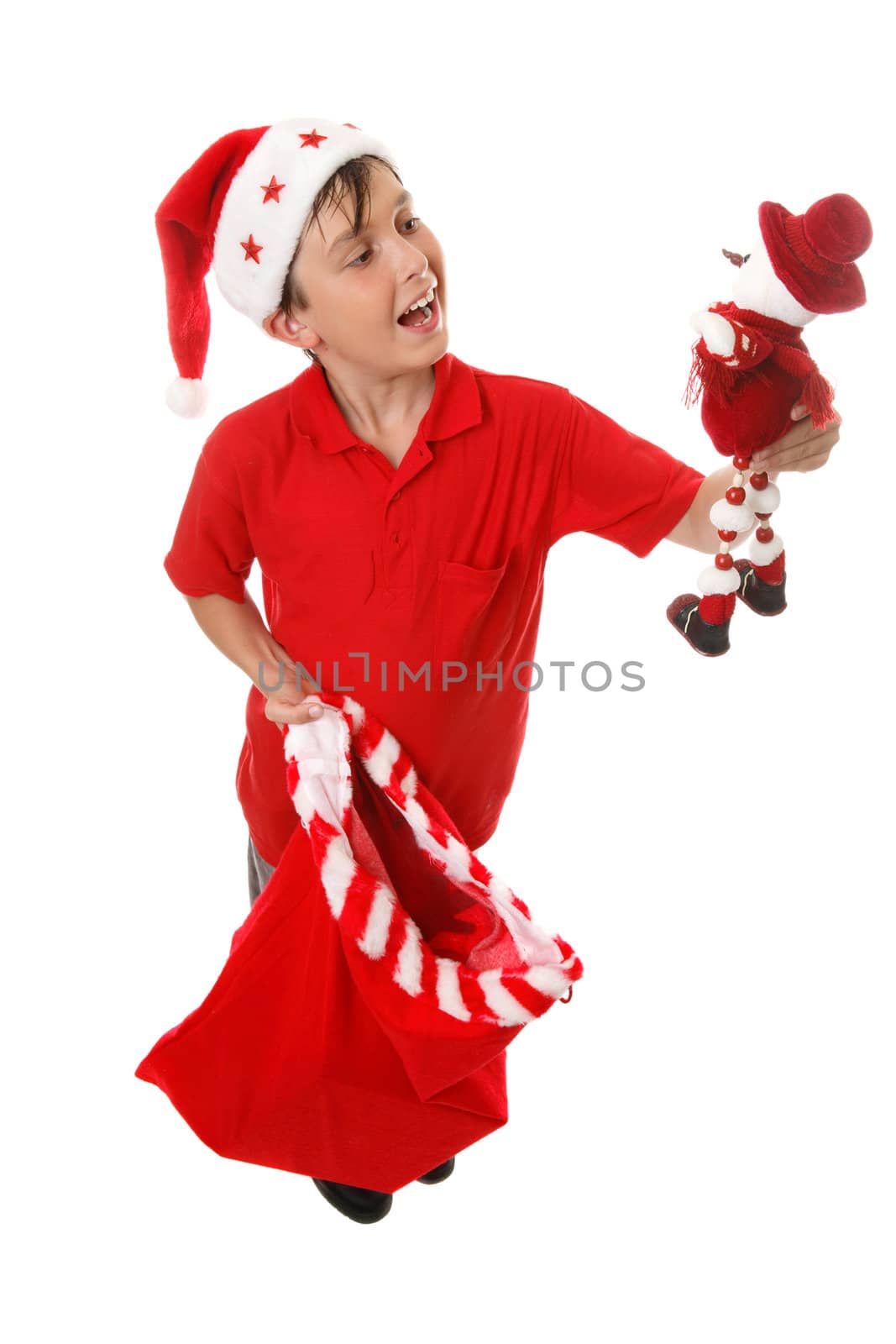 A boy holding a Christmas sack and a toy snowman.  White background.