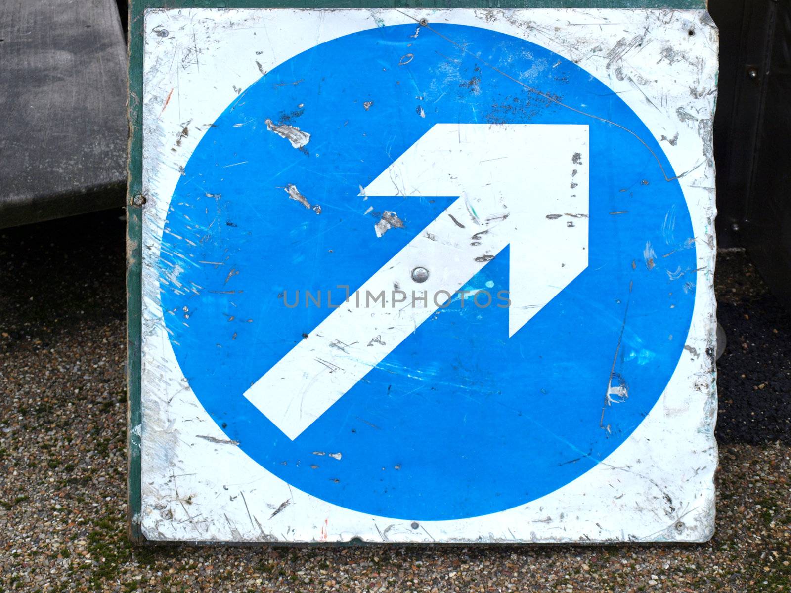 Direction sign with white arrow over blue background